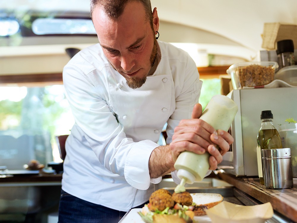 Mitarbeiter richtet Burger an